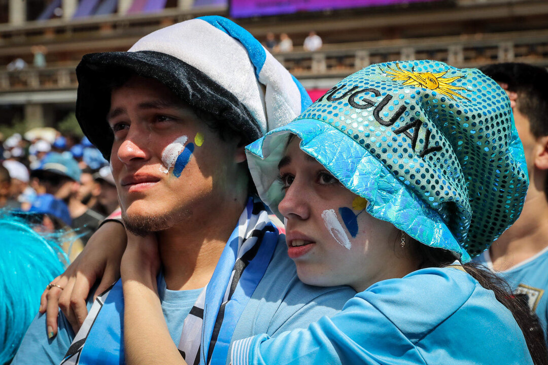 Grupos de personas reaccionan durante la proyección de Ghana - Uruguay del Mundial de Qatar 2022 hoy, en Montevideo (Uruguay). EFE/ Raúl Martínez