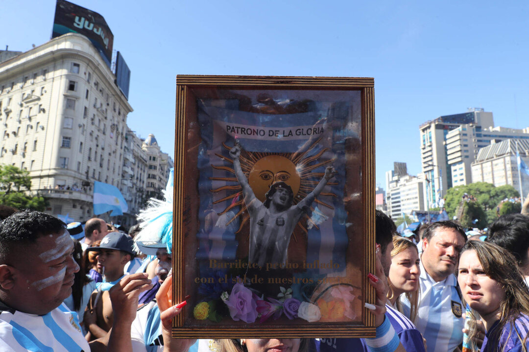 Hinchas de Argentina fueron registrados este domingo, 18 de diciembre, al celebrar, con una imagen enmarcada de Diego Armando Maradona, luego de que la selección nacional de fútbol de su país ganara el Mundial FIFA de Qatar 2022, en el Obelisco de Buenos Aires, en la capital Argentina. EFE/Raúl Martínez