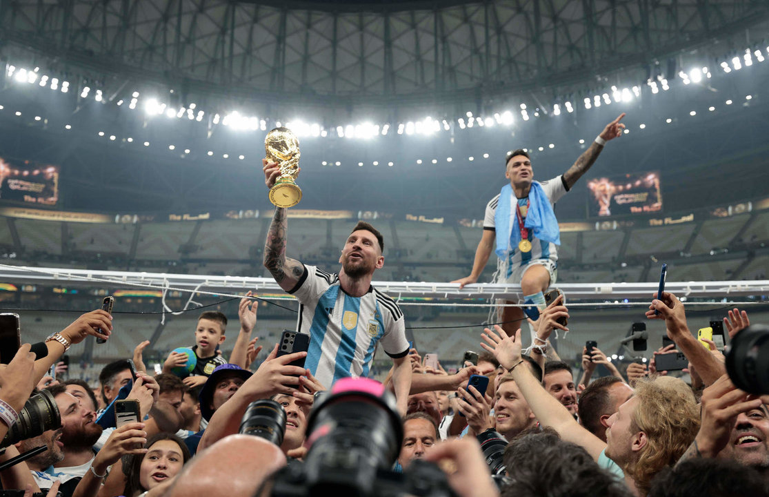 Lionel Messi, alzado en hombros y con el trofeo en la mano, celebra la conquista del Mundial. EFE/ Juan Ignacio Roncoroni